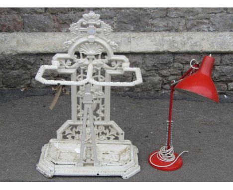 A late Victorian cast iron two divisional umbrella stand, the raised back with decorative  stylised dolphin, urn, shell, face