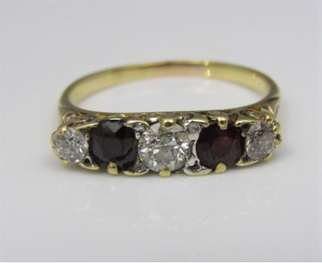 A five stone ring set with one diamond to each shoulder and a single ruby, central stone moissanite replacement, one red ston