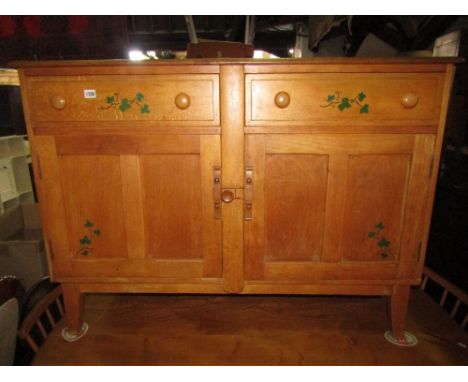 A vintage Ercol light elm and beechwood dresser fitted with two frieze drawers over a pair of twin panelled doors with centra