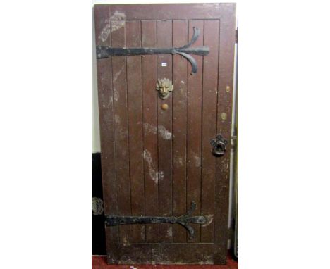 A good quality reclaimed heavy oak front door, with Gothic style strap work hinges, handle and lions mask knocker (lacks ring