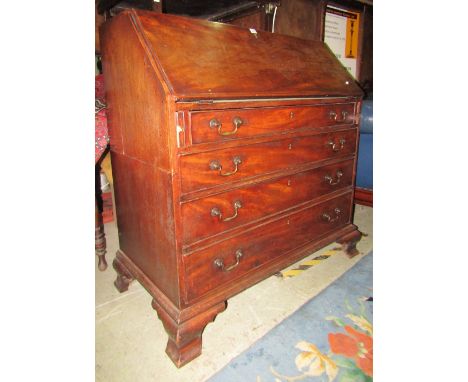A Georgian mahogany bureau, the fall flap enclosing a fitted interior of small drawers, pigeon holes and central cupboard ove