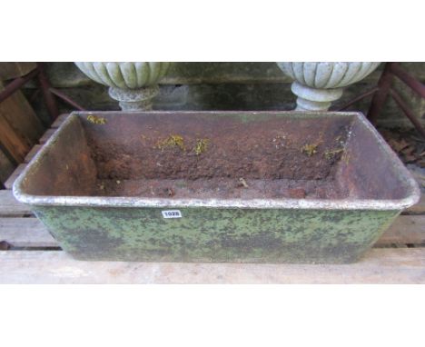 A cast iron trough of rectangular form with rounded front corners and weathered green painted finish, 70 cm long x 33 cm wide