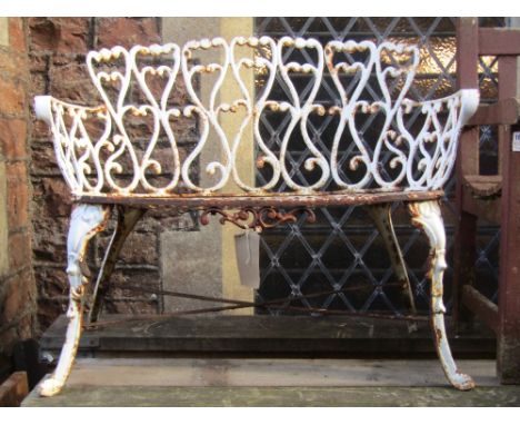 A small decorative cast iron two seat garden bench with pierced and scrolled detail and swept supports united by an x frame s