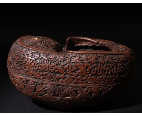 An Islamic Persian Coco Kashkul Beggar's Bowl, Engraved with Islamic Calligraphy & Floral Motifs. L: Approximately 25.5cmProv