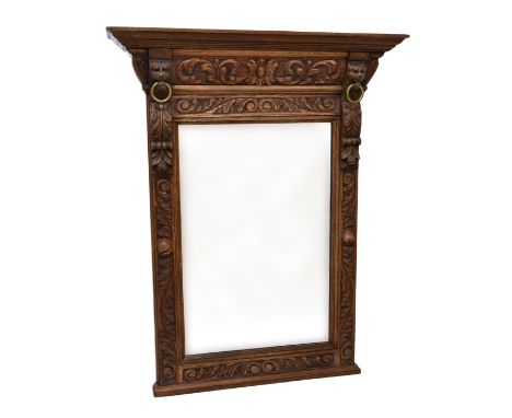 A late 19th century carved oak console mirror the flared cornice on foliate and lion mask carved brackets with brass looose r