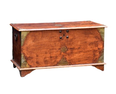 A 19th century brass bound teak trunk the moulded top with central floral brass plaque and corner mounts, iron handles to sid