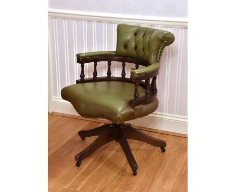 A mahogany and leather button back swivel desk chair late 20th century, the baluster spindle back with buttoned olive green l