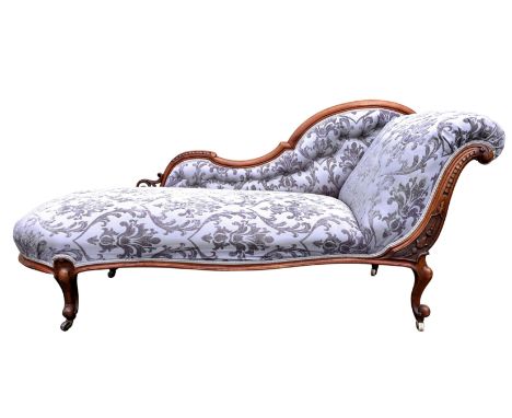 A Victorian carved walnut chaise longue the pierced, moulded showframe carved with foliage and scales, upholstered in recent 