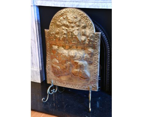An early 18th century style brass firescreen, Victorian, of arched form, repoussé decorated with a pair of heraldic lions abo