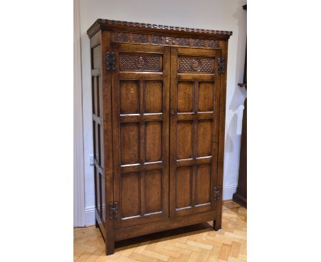 A Maple &amp; Co. panelled, joined oak wardrobe in the Elizabethan manner first half 20th century, maker's label inside door,