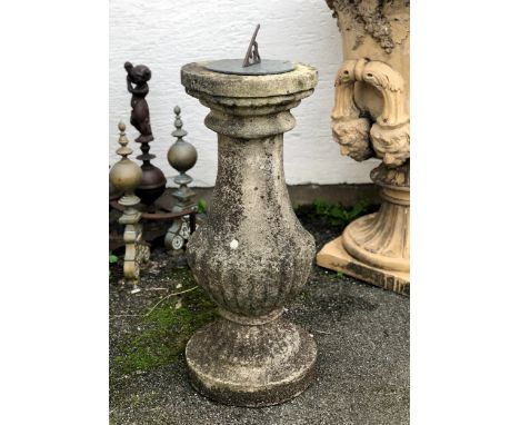 A composite stone and brass sundial of half gadrooned baluster form, 30in. (76.2cm.) high.