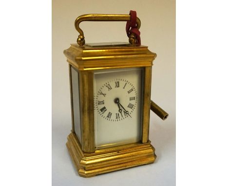 A Small Brass Cased Carriage Clock, The white enamel dial having Roman numerals, 10cm high, with key