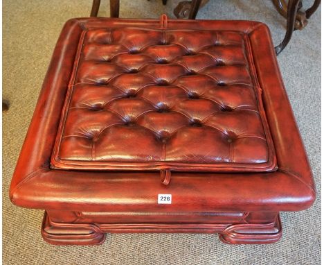 A Chesterfield Ox Blood Pouffe/Coffee Table, With a detachable top enclosing a glass surface, 33cm high, 79cm wide 