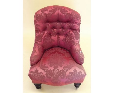 A small Victorian button upholstered armchair on ebonised supports