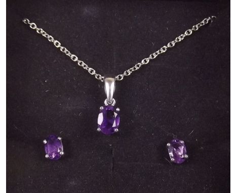 A silver amethyst pair of earrings and matching pendant