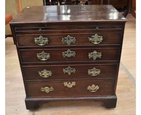 A George III mahogany chest of drawers with a pull-out vanity shelf to the top. It has four drawers with brass swing handles 