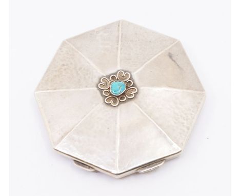 An Arts &amp; Crafts style silver octagonal compact, planished pannelled body, the cover inset with turquoise cabochon within