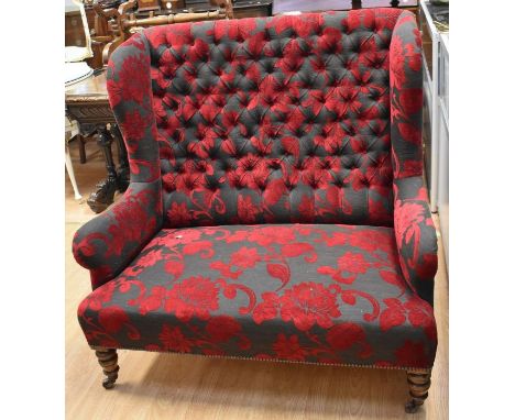A mid Victorian walnut twin winged double seated armchair with crinoline seats, full button backed, turned legs, in pot caste