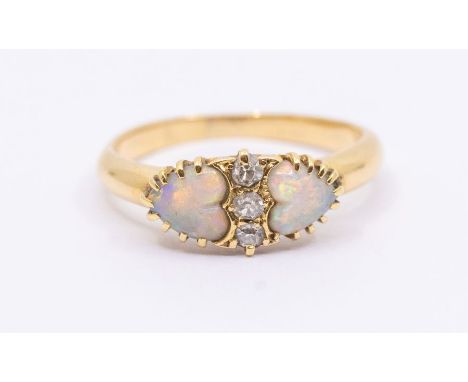 An early 20th century opal and 18ct gold ring, comprising a central  row of three diamonds, set either side with heart shaped