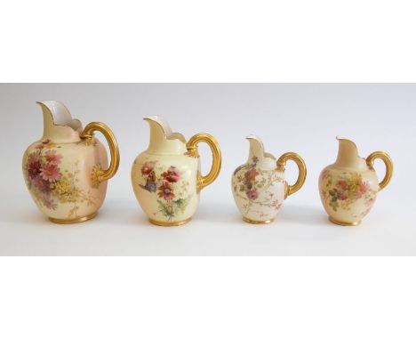 Early 20th Century set of four blush ivory Royal Worcester jugs with flower detail, gilt handles