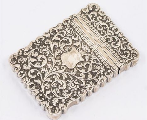 An Asian possibly Indian low grade silver card case, profusely chased scrolling foliate decoration, with central vacant shiel