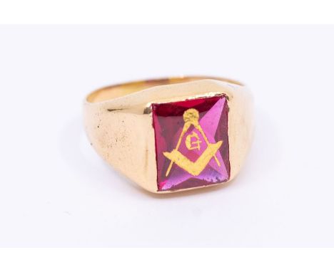 A Masonic 9ct gold and synthetic ruby ring, comprising a square flat synthetic ruby cabochon inlaid with gilt square and comp