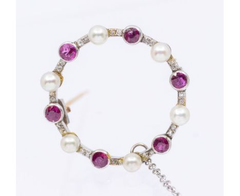 An Edwardian ruby, diamond and pearl set platinum brooch, comprising a circular open design collet set with round, mixed cut 