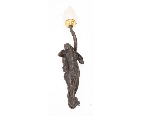 A decorative wall lamp in the style of Liberty, with the torch flame as the shade