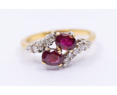 A ruby and diamond 18ct gold ring, comprising a cross over set with two oval rubies, within diamond set borders, size N, tota