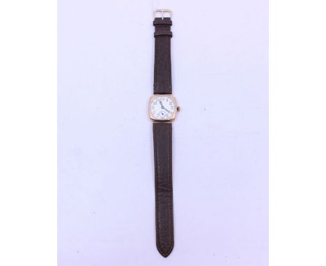 An early 20th century gents 9ct rose gold wristwatch, circa 1918, comprising a cushion shaped case, round enamel dial with li
