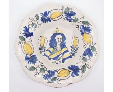 A Dutch Delft Royal Commemorative Dish, late 17th century, of fluted circular form, painted in yellow, blue and green with a 