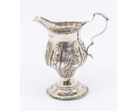 A George III silver ogee shaped cream jug, later chased with flowers and foliage, on spreading circular foot, hallmarked by T