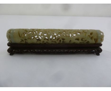A Chinese cylindrical jade scroll holder carved and pierced with prunus blossom and leaves with two pierced and carved pull o