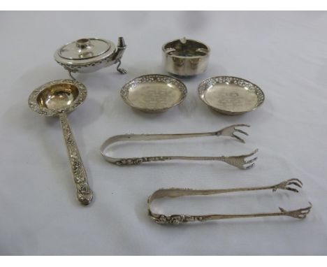 A quantity of Chinese white metal to include a tea strainer, two pairs of tongs, two coasters, an ashtray and an oil lamp A/F