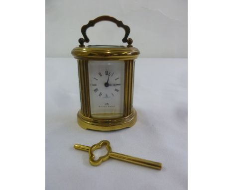 Matthew Norman miniature brass oval carriage clock, to include key