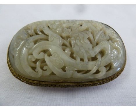 A Chinese mutton fat jade and gilt metal belt buckle, carved and pierced with leaves and flowers
