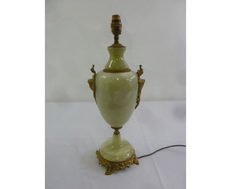 An onyx and gilt metal table lamp of ovoid form on raised circular base