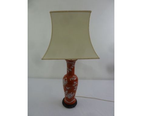 A Chinese baluster form red ground table lamp and silk shade