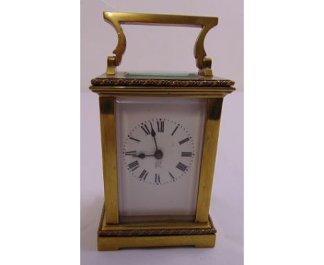 A French brass carriage clock of customary form with Roman numerals and enamel dial