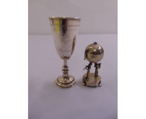 A Russian late 19th century silver spice container of globular form supported by two figures playing musical instruments on a