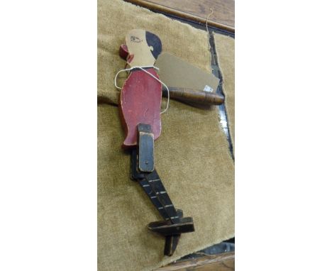 A late Victorian carved wood and painted puppet figurine with articulated legs and handle to rear