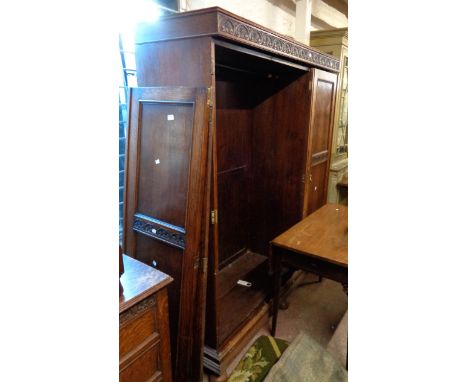 A 1.5m early 20th Century polished oak triple wardrobe with hanging space and four drawers enclosed by a central mirror panel