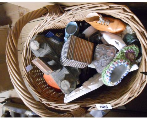 A vintage wicker basket containing a selection of collectable items including carriage clock case, small selection of coins, 