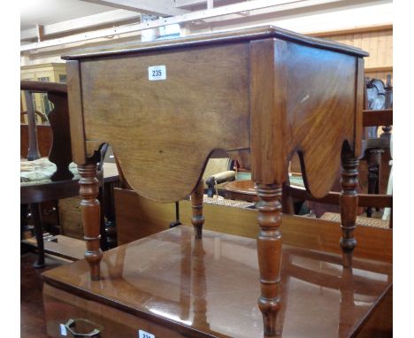 A Victorian mahogany commode with china liner and shaped apron, set on turned legs