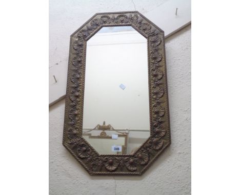 A vintage embossed brass clad framed octagonal wall mirror with decorative border