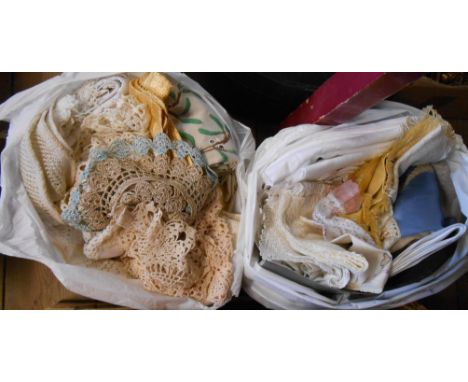 Two bags containing a quantity of textiles including crochet tray cloths, damask and embroidered tray cloths and mats, etc.