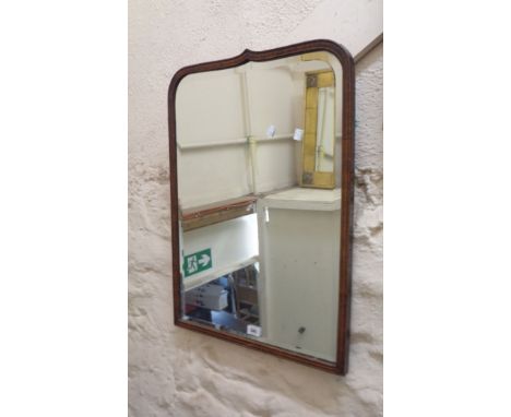 A vintage stained wood framed bevelled wall mirror with shaped top plate