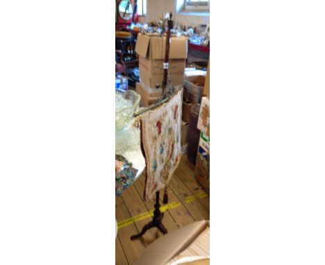 A 19th Century pole screen with ornate cast brass suspender and tapestry panel, set on a slender tripod base