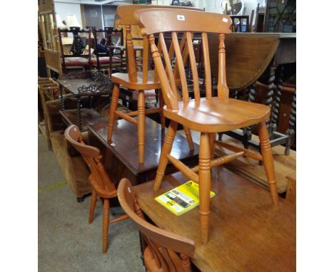 A set of four reproduction stained wood Windsor style kitchen chairs with moulded solid seats, set on ring turned supports