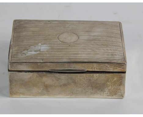 A silver table cigarette box, with engine turned decoration to the hinged lid, indistinct marks, 12.5cm x 9cm x 5cm.